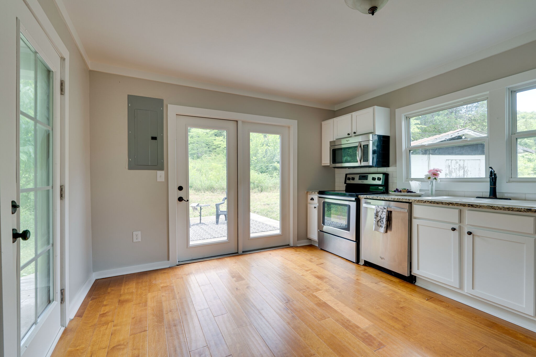 2154 Temperance Hall Road Lancaster, TN 38569 - Photo 14 of 35 a large white kitchen with granite countertop a stove top oven a sink and dishwasher with wooden floor