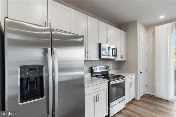 a kitchen with stainless steel appliances a sink and a large window