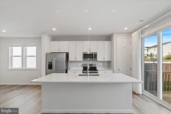 a kitchen with kitchen island a sink stainless steel appliances and cabinets