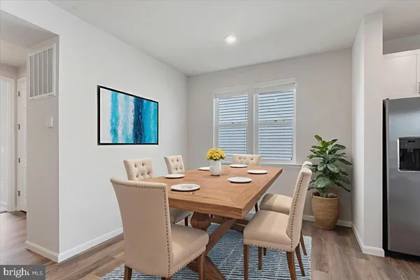 a kitchen with a refrigerator and a wooden floor
