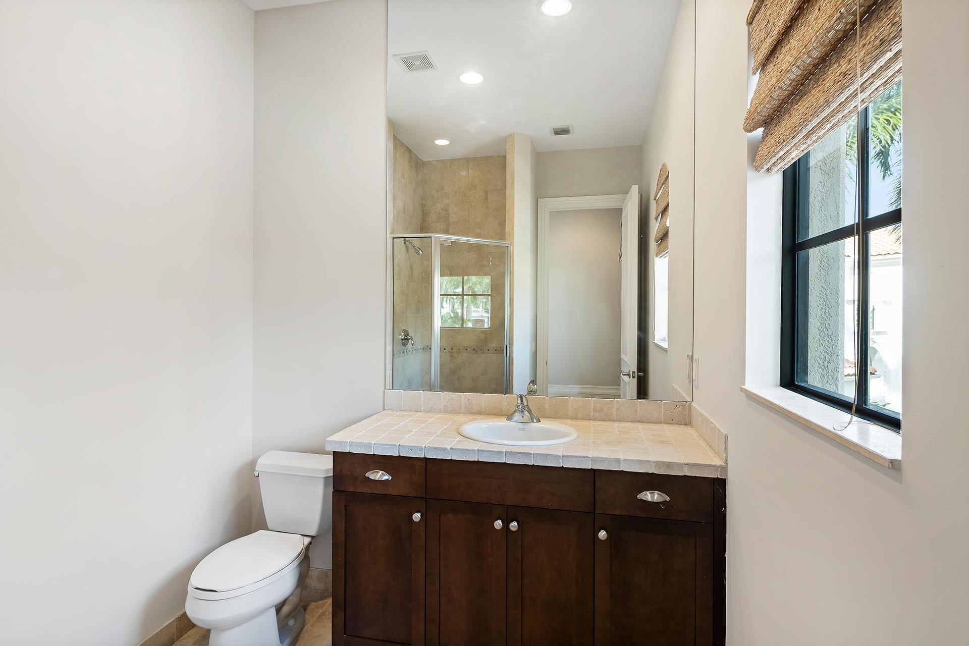 17895 Cadena Drive Boca Raton, FL 33496 - Photo 41 of 64 a bathroom with a granite countertop sink toilet a large mirror and a window