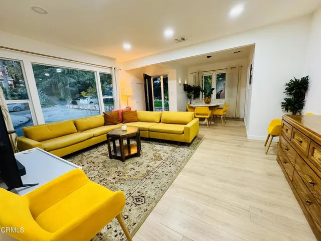 a living room with furniture rug and large windows