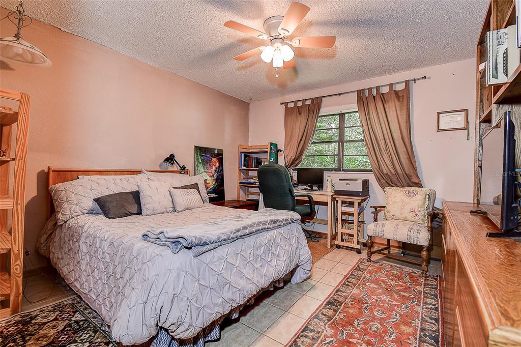 7323 Ray Browning Road Brooksville, FL 34601 - Photo 14 of 46 a bedroom with a bed a large window with table and chairs