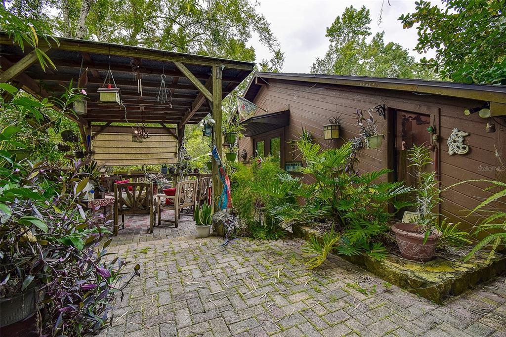 7323 Ray Browning Road Brooksville, FL 34601 - Photo 24 of 46 a view of a patio with table and chairs and potted plants