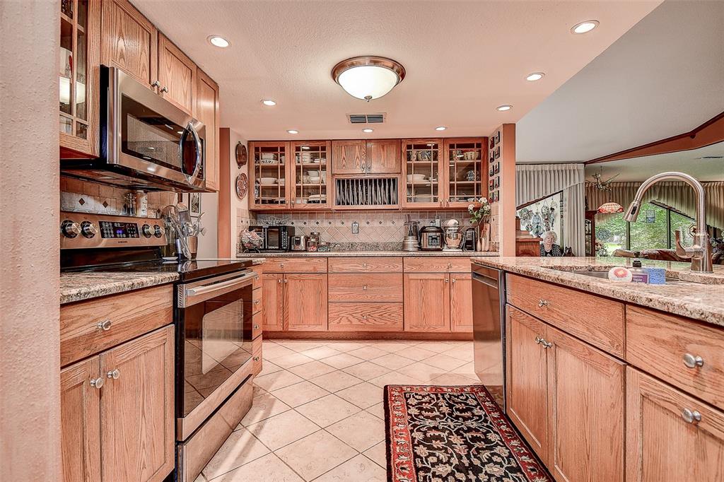 7323 Ray Browning Road Brooksville, FL 34601 - Photo 3 of 46 a kitchen with stainless steel appliances granite countertop a stove a sink and a microwave