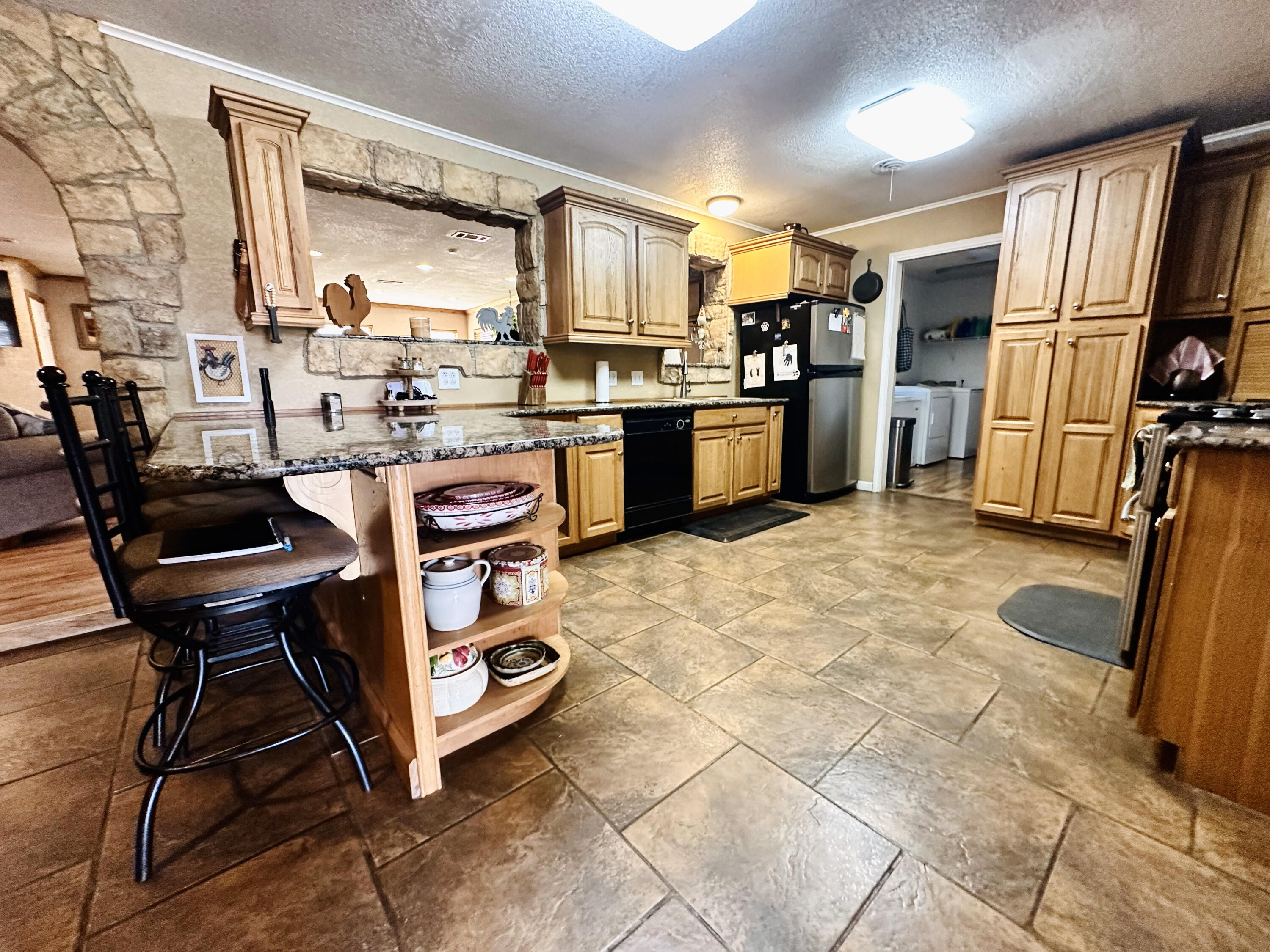 403 Osage Avenue Post, TX 79356 - Photo 13 of 31 a kitchen with stainless steel appliances kitchen island granite countertop a refrigerator and a stove top oven