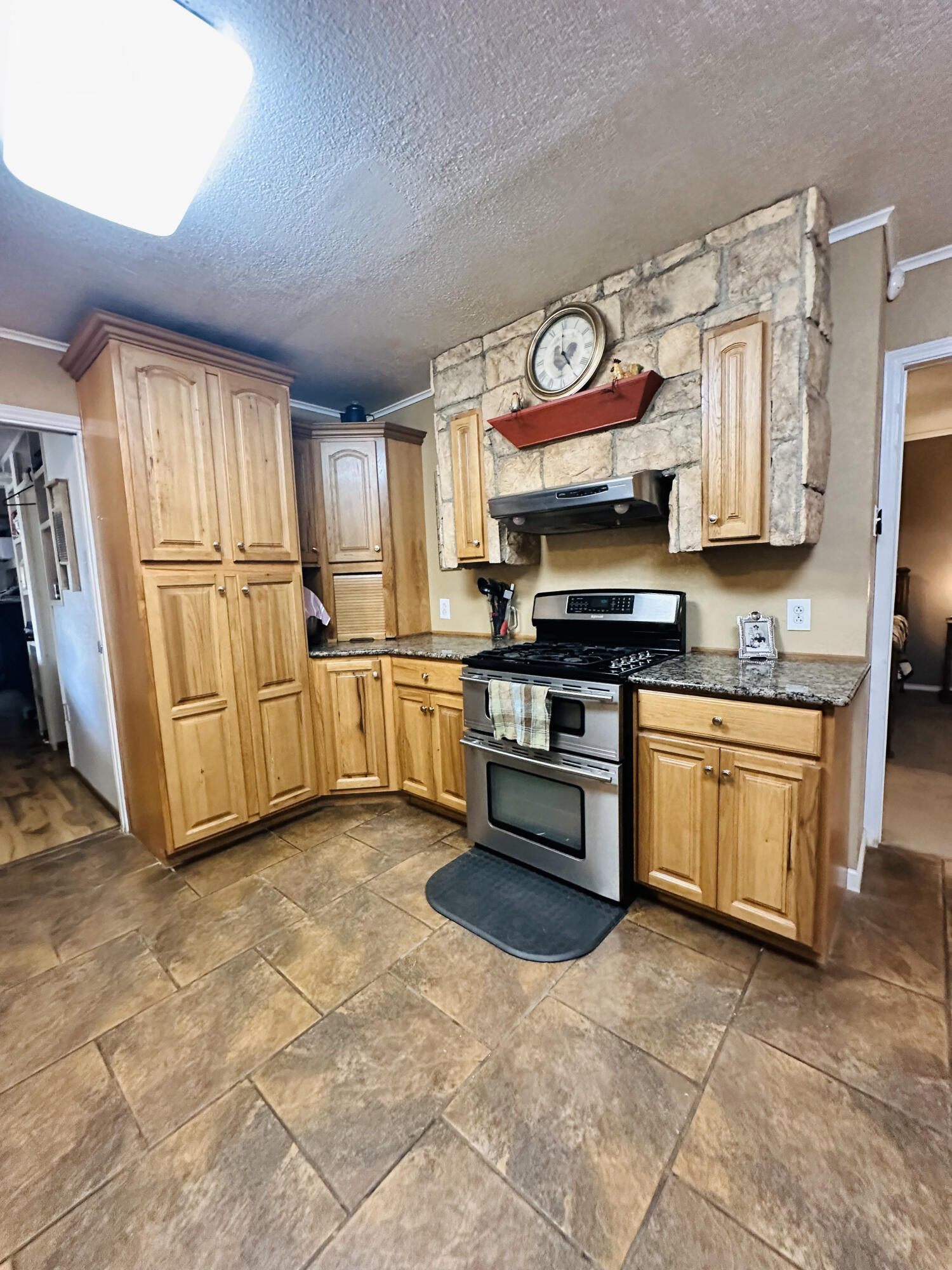 403 Osage Avenue Post, TX 79356 - Photo 14 of 31 a kitchen with stainless steel appliances granite countertop a stove a sink and a refrigerator