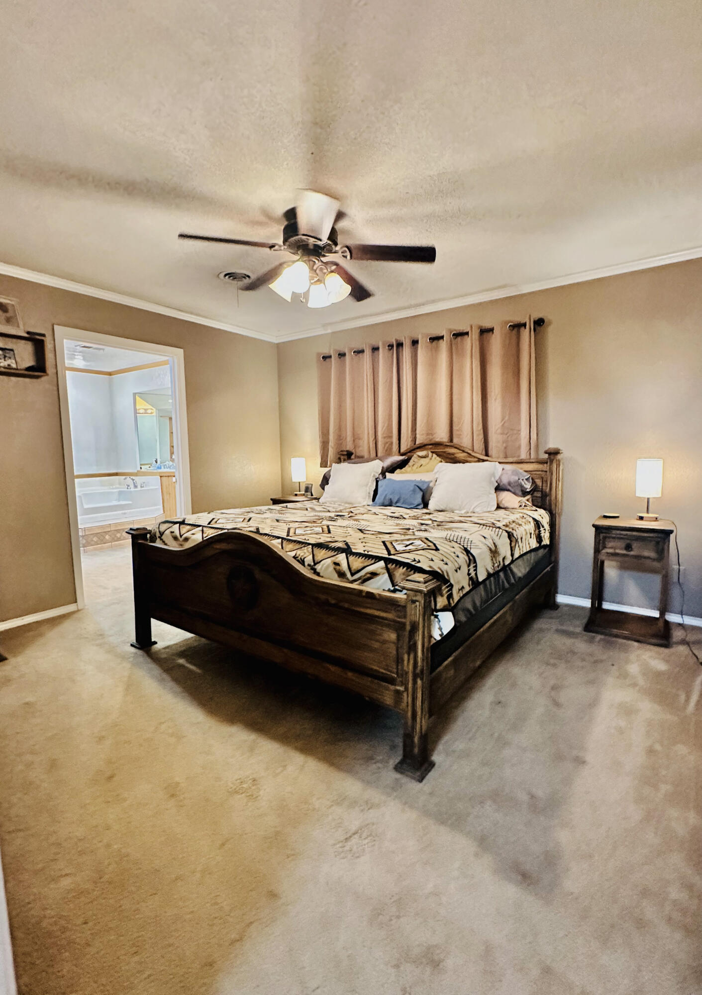 403 Osage Avenue Post, TX 79356 - Photo 16 of 31 a bedroom with a bed and a chandelier