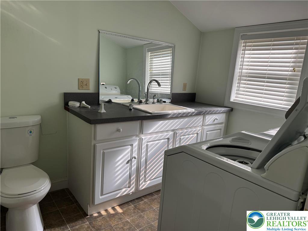 1352 Main Street Hellertown, PA 18055 - Photo 4 of 9 a bathroom with a toilet a sink and a mirror