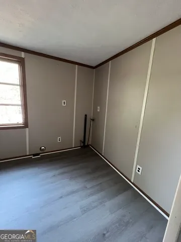 an empty room with wooden floor and window
