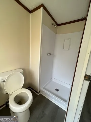 a bathroom with a granite countertop toilet and a shower