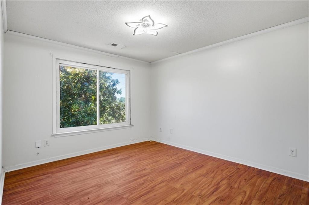 3018 Broadleaf Trail Road Fairburn, GA 30213 - Photo 13 of 26 a view of an empty room with wooden floor and a window