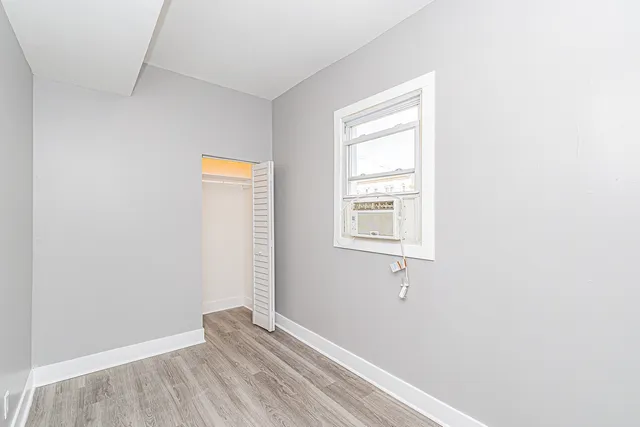 a view of a small space with wooden floor and a window