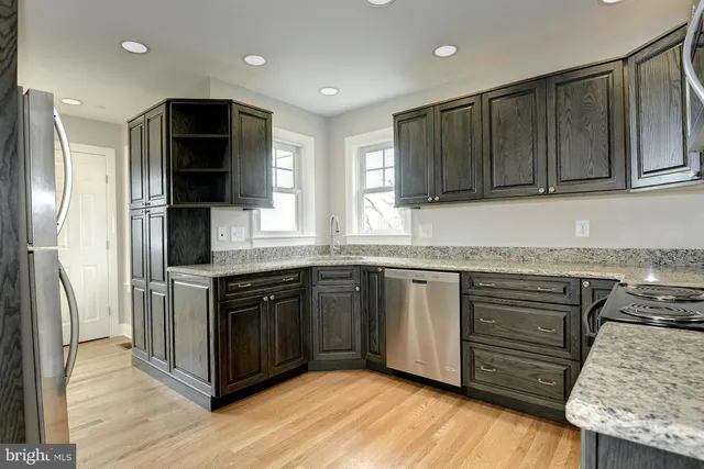a kitchen with stainless steel appliances granite countertop a stove a sink and a refrigerator