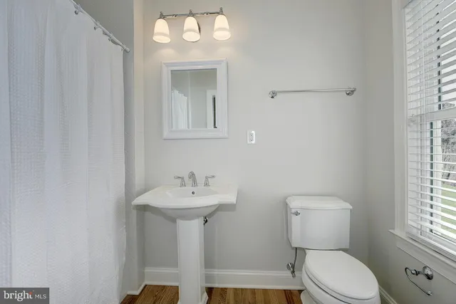a bathroom with a sink toilet and a window