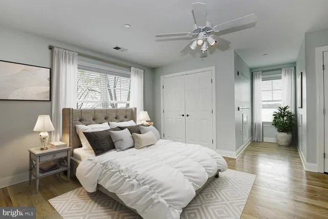 a bedroom with a large bed chandelier and a window