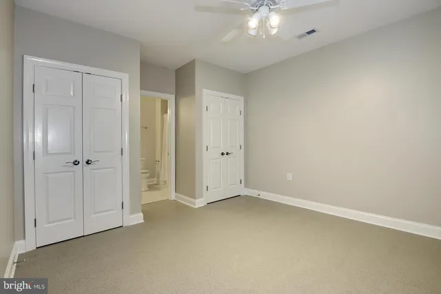 an empty room with chandelier fan