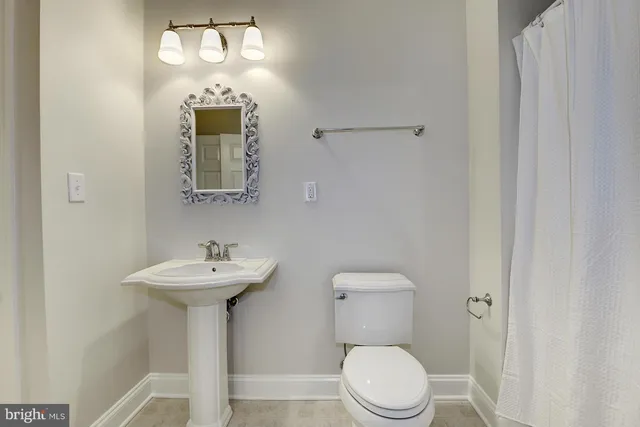a white toilet sitting next to a bathroom sink