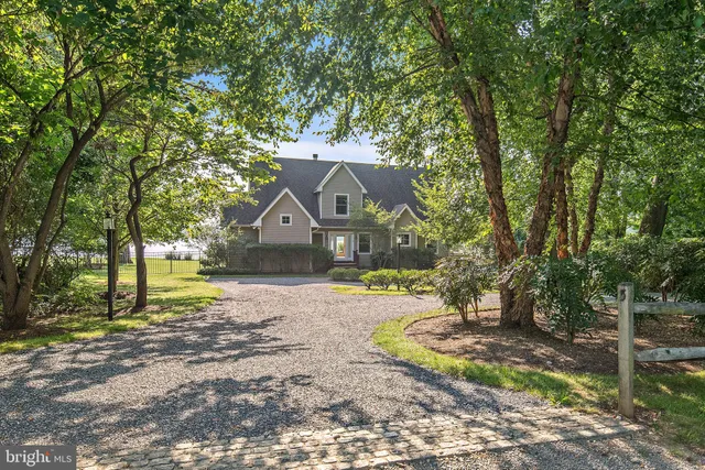 a front view of a house with a yard and tree s