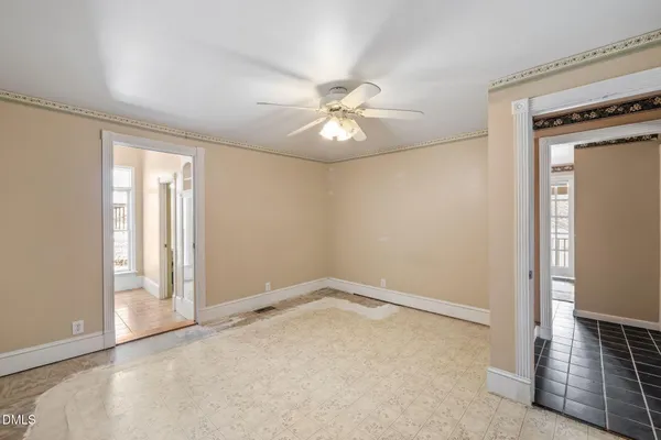 an empty room with windows and fan
