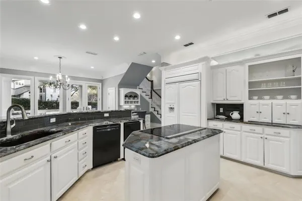 a large kitchen with kitchen island a large counter top space a sink stainless steel appliances and cabinets