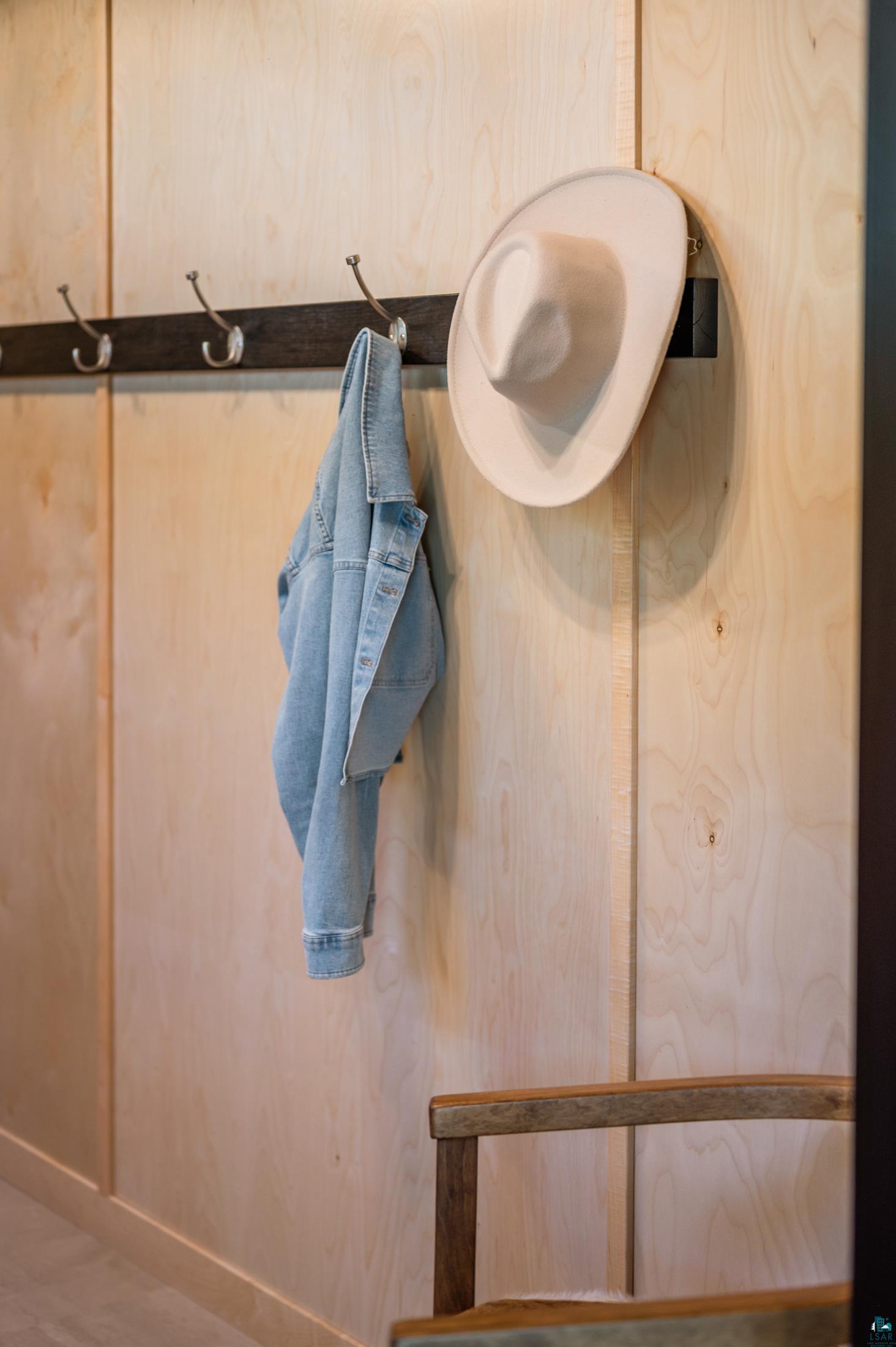 3778 East County Road Barnum, MN 55707 - Photo 14 of 52 Light wood wall paneling with a dark wood coat rack featuring multiple metal hooks