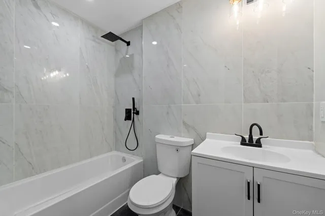 a white toilet sitting next to a bath tub