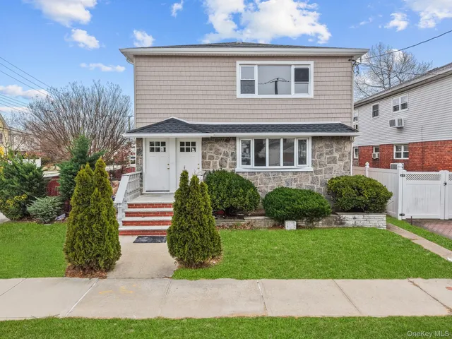 a front view of a house with a yard and potted plants