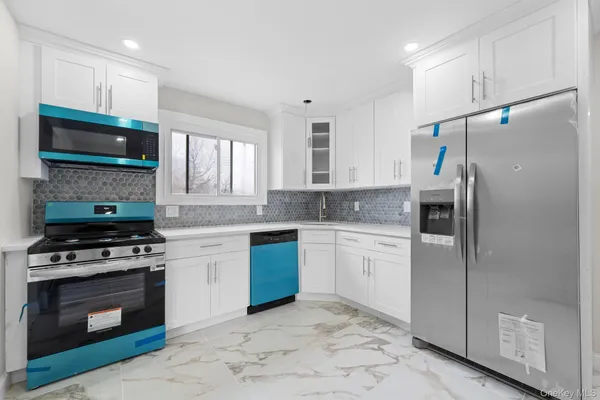 a kitchen with granite countertop a refrigerator stove and microwave