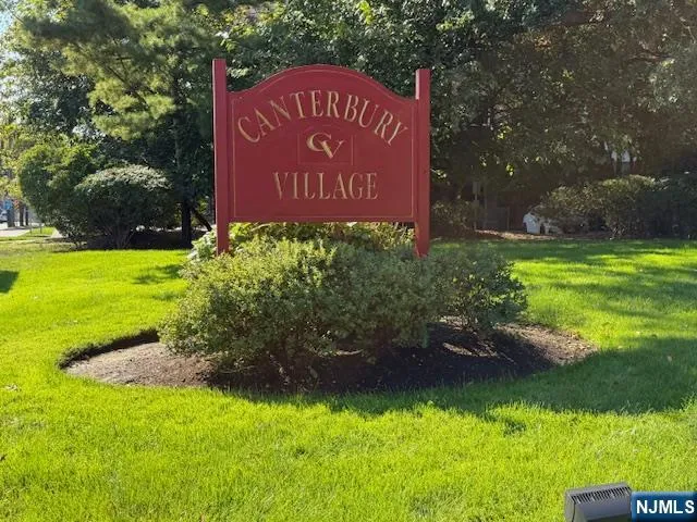a sign of golf club on a wall under a tree