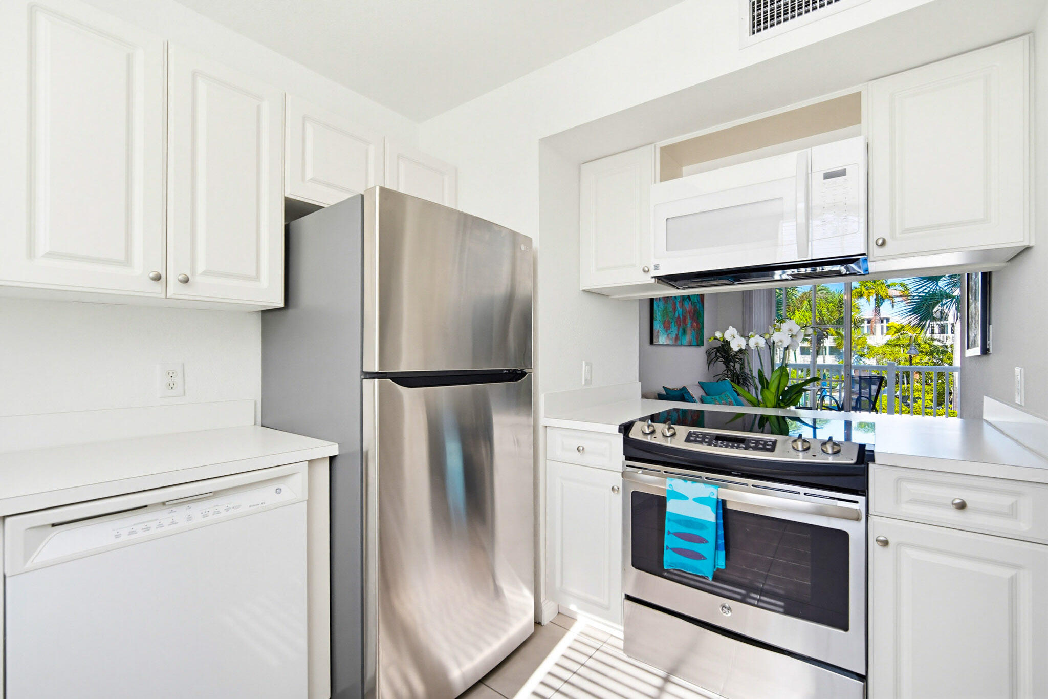 63 Seaside N Court Key West, FL 33040 - Photo 24 of 40 a kitchen with stainless steel appliances white cabinets and a stove