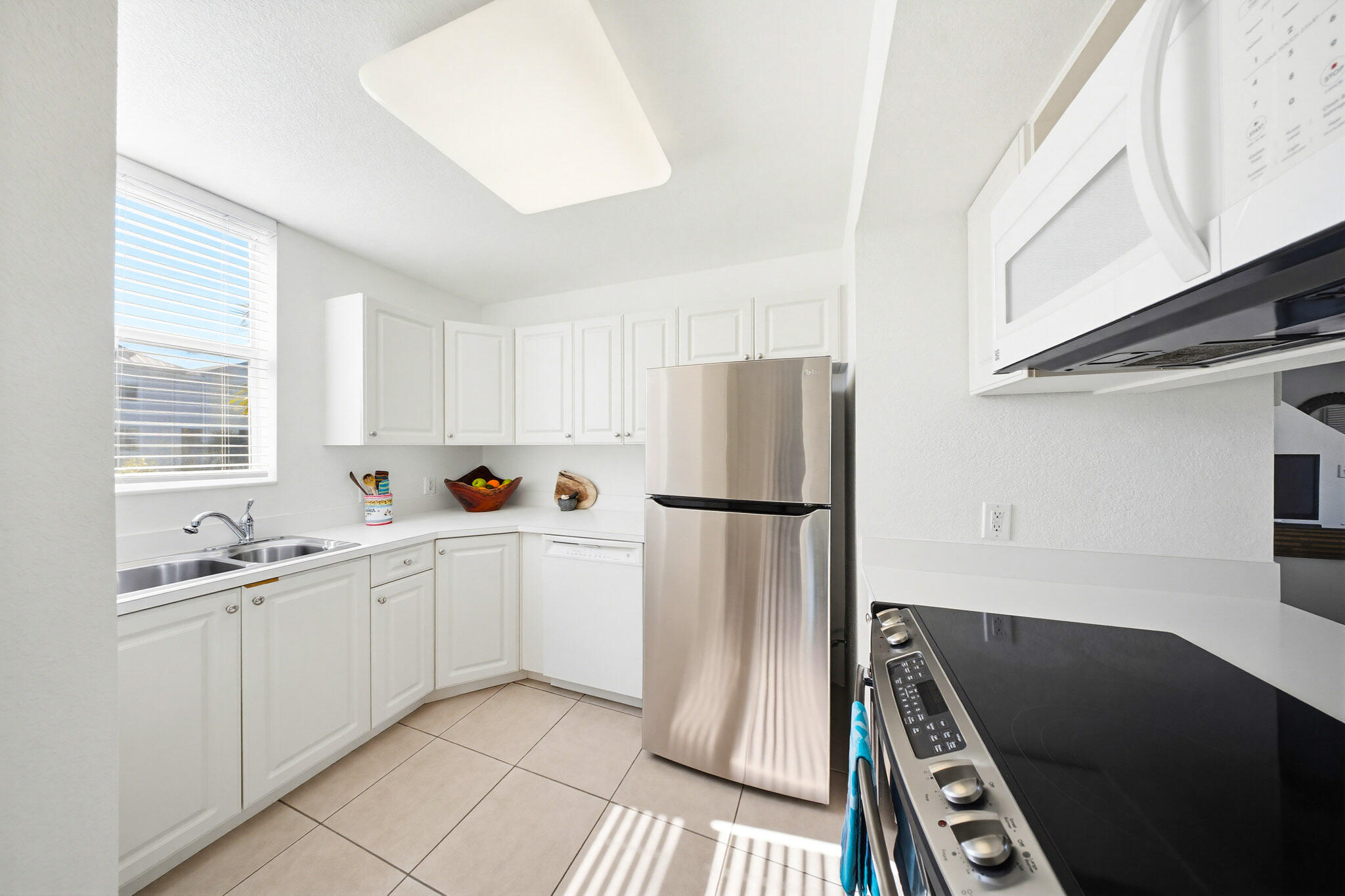 63 Seaside N Court Key West, FL 33040 - Photo 25 of 40 a kitchen with white cabinets and white appliances