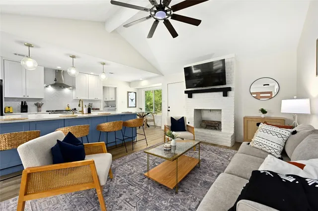 a living room with furniture a flat screen tv and a fireplace