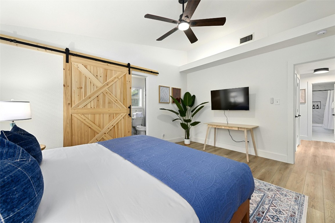 9414 Meadow Vale Austin, TX 78758 - Photo 21 of 37 a bedroom with a bed and a flat screen tv