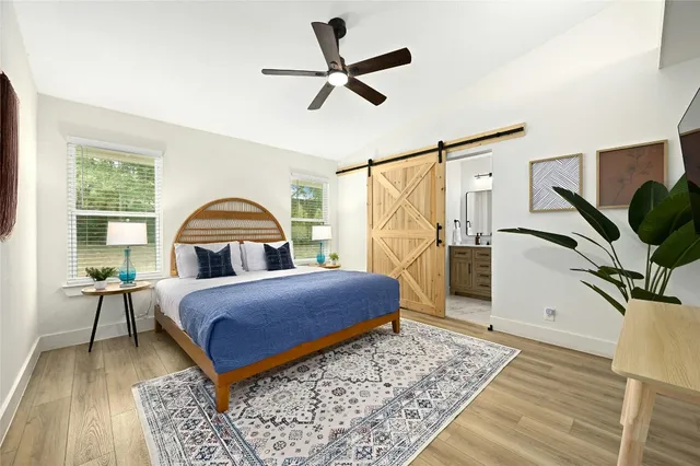 a bedroom with a bed a window and a flat screen tv