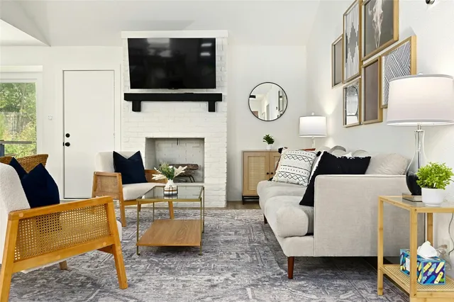 a living room with furniture a flat screen tv and a fireplace