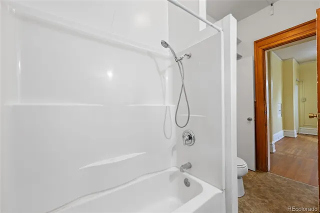 a bathroom with a bath tub with a shower