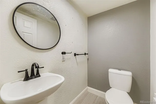 a bathroom with a toilet a sink and a mirror