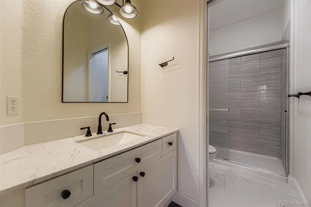 a bathroom with a sink mirror and a shower