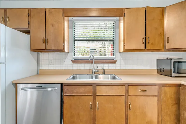 a kitchen with a sink cabinets and a large window