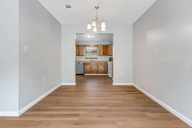 a view of a kitchen with a sink and dishwasher wooden floor