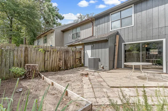 a backyard of a house with chairs and wooden fence