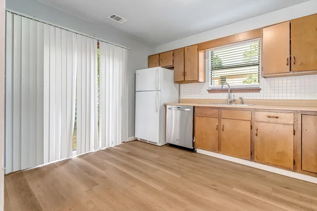 a kitchen with a refrigerator a sink and a window