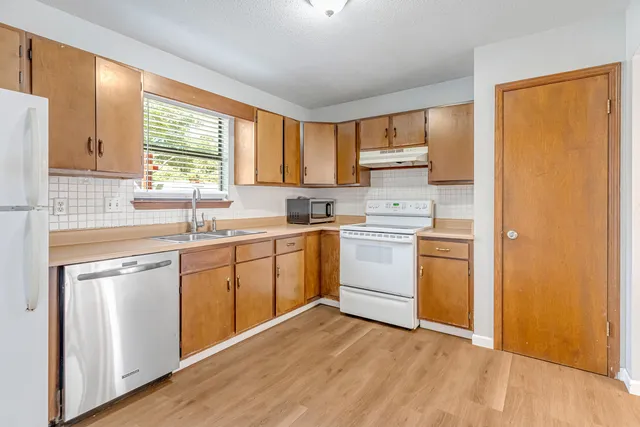 a kitchen with white cabinets and white appliances