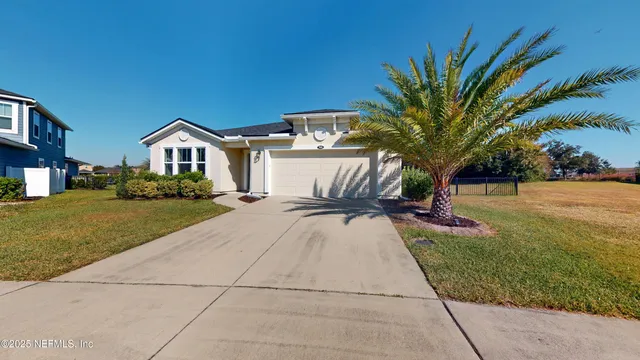 a front view of a house with a yard and trees