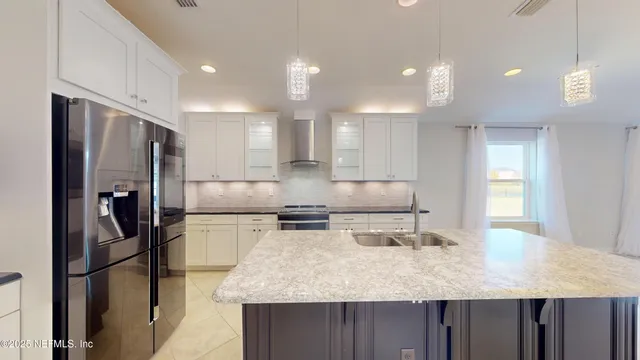 a kitchen with stainless steel appliances granite countertop a sink refrigerator and microwave