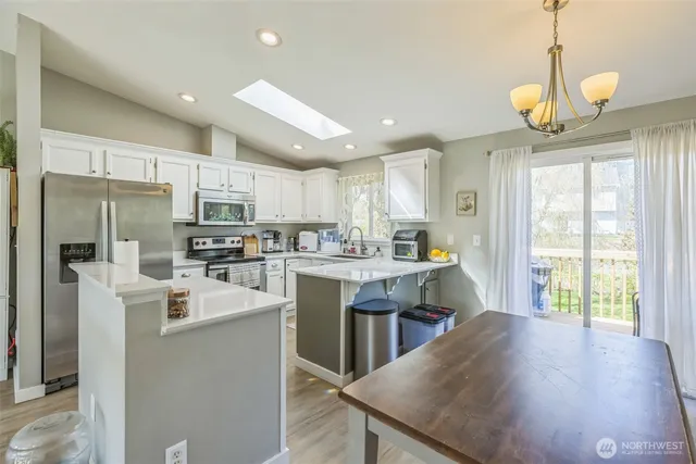 a kitchen with counter top space a sink appliances and cabinets