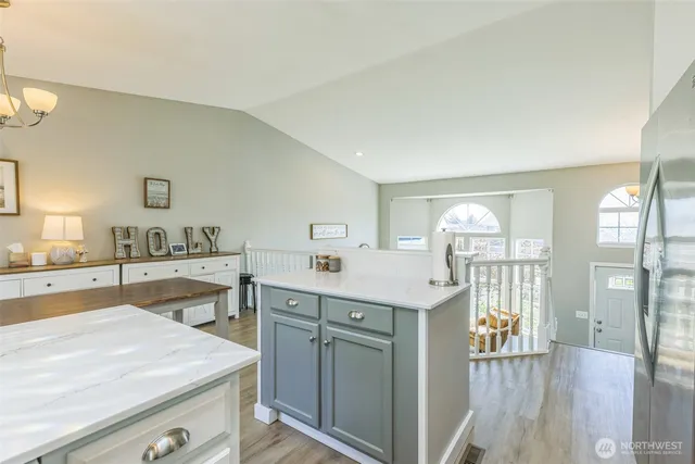 a kitchen that has a lot of cabinets and wooden floor