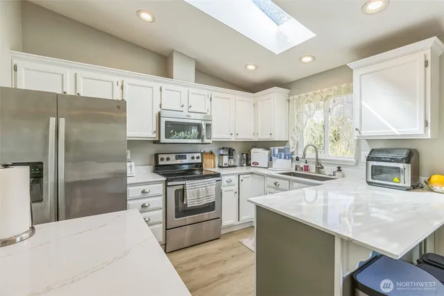 a kitchen with stainless steel appliances granite countertop a refrigerator stove microwave and sink