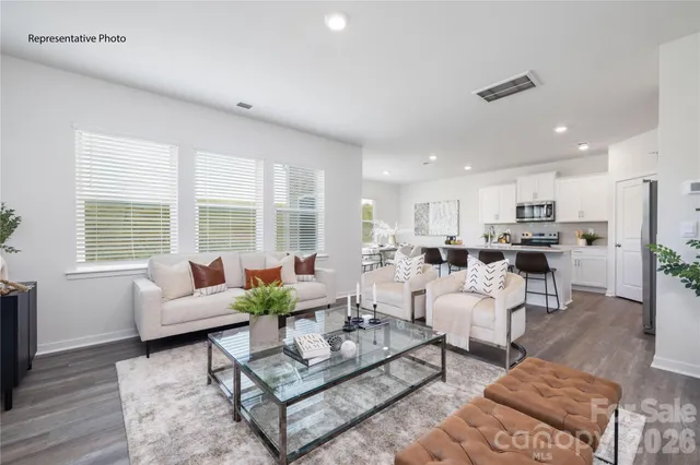 a living room with furniture kitchen and a large window